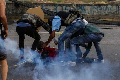 Un grupo de manifestantes ayudan a un herido durante los enfrentamientos.