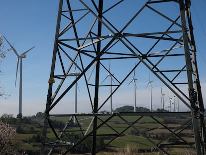Molinos de viento, vistos tras una torre de tendido eléctrico, en Tarragona.