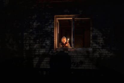 Catherine, de 70 años, miraba por la ventana mientras sostenía una vela para iluminar el interior de su casa durante un corte de energía, el 20 de octubre, en Borodianka, región de Kiev. Los ataques aéreos rusos cortaron el suministro de energía y agua a cientos de miles de ucranios. El presidente Zelenski cree que se trata de una campaña rusa para llevar a Ucrania al frío y la oscuridad, y así hacer imposibles las conversaciones de paz.