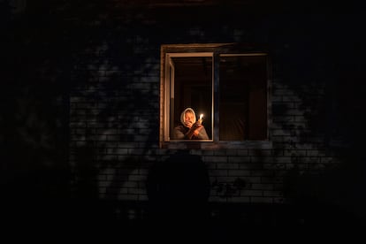 Catherine, de 70 años, miraba por la ventana mientras sostenía una vela para iluminar el interior de su casa durante un corte de energía, el 20 de octubre, en Borodianka, región de Kiev. Los ataques aéreos rusos cortaron el suministro de energía y agua a cientos de miles de ucranios. El presidente Zelenski cree que se trata de una campaña rusa para llevar a Ucrania al frío y la oscuridad, y así hacer imposibles las conversaciones de paz. 