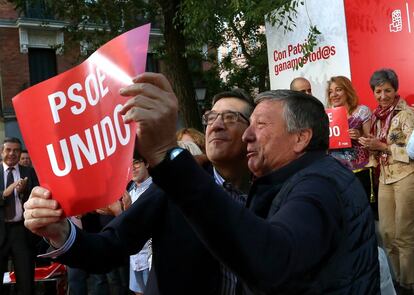 Patxi López sostiene un cartel junto con un militante durante el mitin en Madrid.