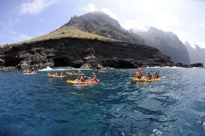 Tourists on kayaks in front of Los Gigantes cliff in Tenerife (Canary Islands).