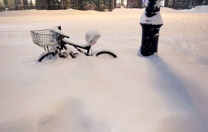 Una bici enfonsada per la neu en un carrer de Nova York.