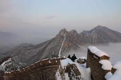 Varios turistas visitan la muralla china cubierta de nieve en la zona Jiankou, el 16 de diciembre.
