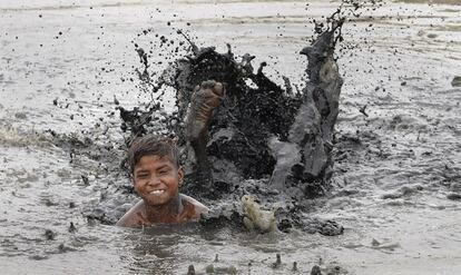 Un niño juega en una charca con agua contaminada durante un día caluroso en Nueva Delhi, India.