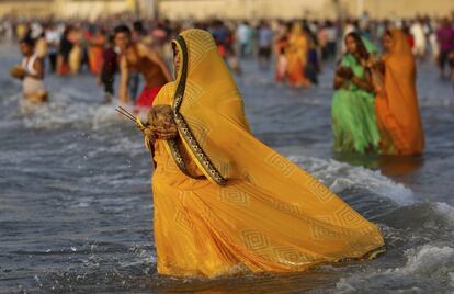 Una mujer se introduce en el mar Arábigo durante sus oraciones al atardecer en Mumbai (India).