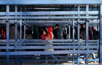 Una mujer junto a su hijo espera para registrarse en el campo de refugiados en Slavonski Brod (Croacia).