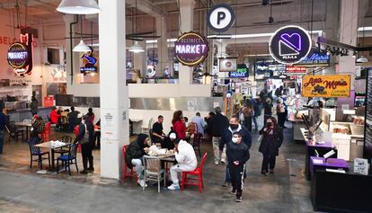 Varias personas comen en el Grand Central Market, en Los Ángeles, luego de que las instalaciones reabrieran, el 15 de marzo.