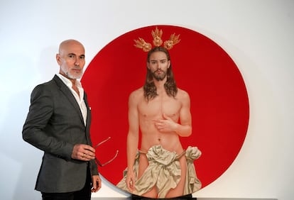 El artista Salustiano García posa junto a su cartel para la Semana Santa sevillana.