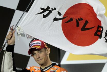 Stoner, piloto de la marca japonesa Honda, muestra una bandera del país asiático tras su victoria en el Gran Premio de Catar como homenaje a los fallecidos por el tsunami.