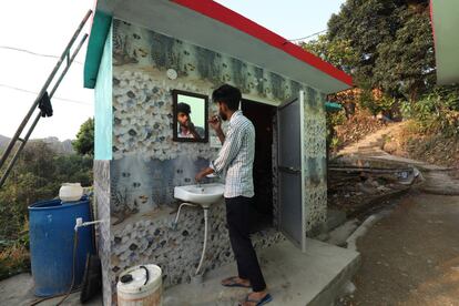 Un hombre se afeita delante de su nueva letrina en Jalot village cerca de Nagrota Bagwan, Dharamsala, India. Está demostrado que las comunidades que han conseguido el 'saneamiento total' (un inodoro en cada hogar) reducen significativamente la defecación al aire libre y las enfermedades.