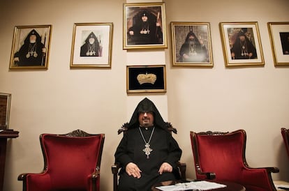 Tatul Anusyan, presidente del consejo espiritual del Patriarcado Armenio de Constantinopla, posa junto a los retratos de varios patriarcas en la iglesia de Surp Vartanants, en Estambul.