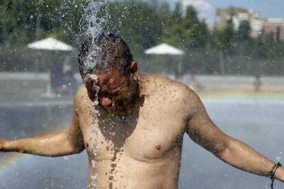 Un hombre se refresca en una de las fuentes de Madrid Río, 5 de julio de 2013. Aunque las temperaturas no serán "extraordinariamente altas", esta situación, según Protección Civil, se podrá prolongar durante los próximos diez días.