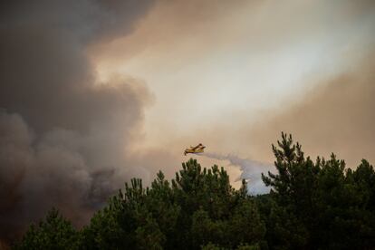 Una avioneta suelta la carga de agua sobre las llamas que se han avivado desde primera hora de la mañana. El incendio ha obligado ha desalojar de sus casas a más de 250 personas.