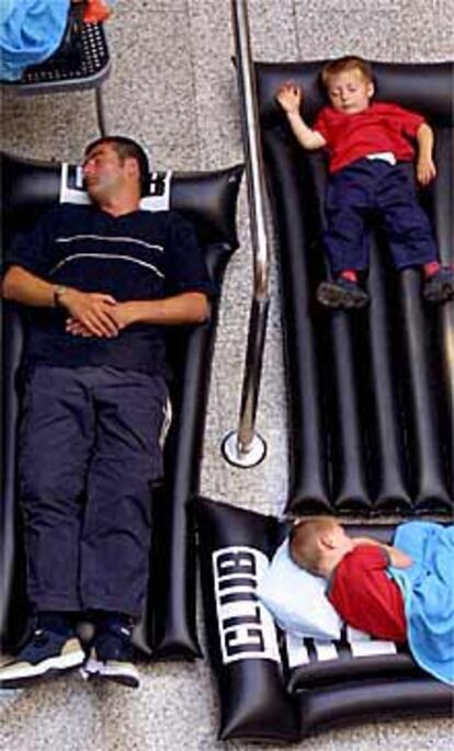 Unos turistas duermen sobre colchonetas en el aeropuerto de Palma.