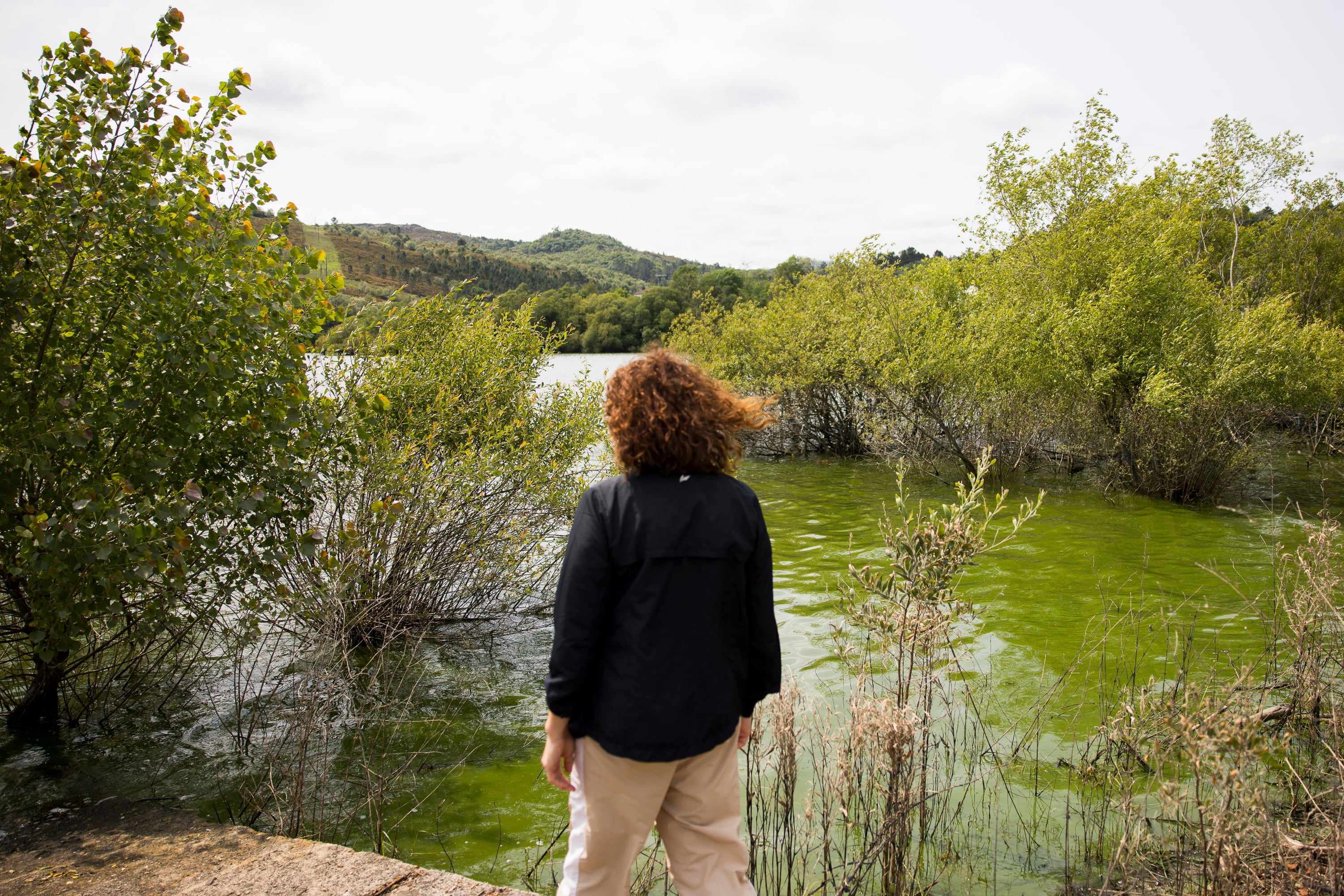 Una vecina contempla el agua contaminada por cianobacterias en As Conchas (Lobeira).