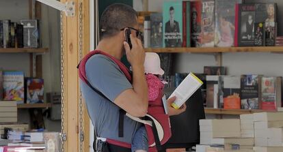 Un joven con un niño, ayer, en una de las casetas de la Fira del Llibre de Valencia.