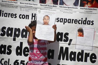 Keila González llora mientras sujeta el cartel con la foto de su madre desaparecida, Marisol González, en Ciudad Juárez (México), el 8 de marzo de 2015.