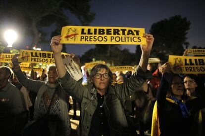 Una mujer sostiene un cartel "Libertat, presos políticos" frente al Parlament.