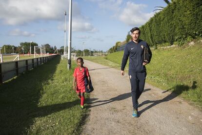 El pequeño Moctar, del prebenjamin B de la Escuela de Mareo, llega al entrenamiento acompañado por Pablo, su entrenador.