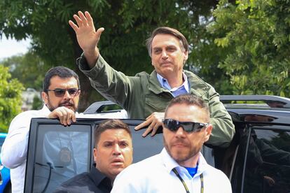 Jair Bolsonaro greets supporters after casting his vote.