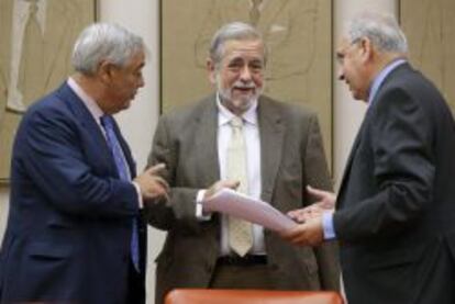 El presidente de la comisión de Presupuestos del Congreso, el socialista Alfonso Guerra (d), y el vicepresidente primero de dicha comisión, el popular Fernando López Amor (i), conversan con el secretario de Estado de Administraciones Públicas, Antonio Beteta (c), momentos antes de la comparecencia de éste para informar del proyecto de Presupuestos Generales del Estado para 2015.