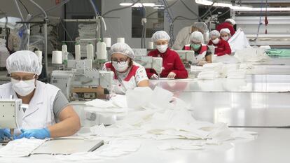 Empleadas de la empresa valenciana Funcotex, que participa en una campaña para fabricar 125.000 mascarillas diarias en esta comunidad.