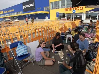 Caty Hamley, con otros tres clientes, juega al Rummikub para entretenerse en su espera.