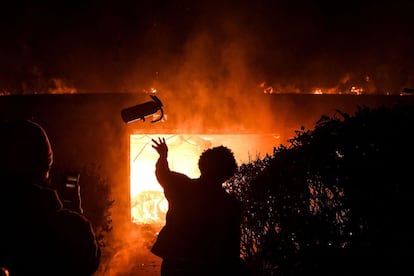 El fiscal del condado de Hennepin (Minnesota), Mike Freeman, presentó los cargos poco después del anuncio de la detención de Chauvin y explicó que no lo hizo antes porque no disponía de pruebas suficientes. En la imagen, un manifestante arroja un extintor a un edificio en llamas durante una manifestación en Minneapolis.