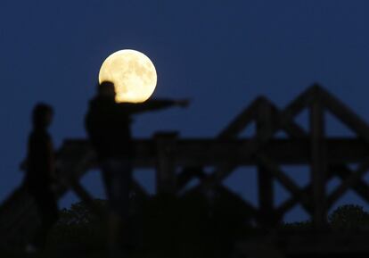 Diverses persones observen la lluna de perigeu, també coneguda com a superlluna, a Mir, Bielorússia.
