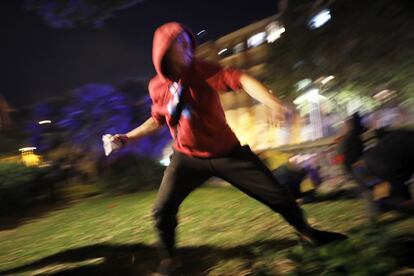 A protester throws a rock during the third day of protests in Barcelona.