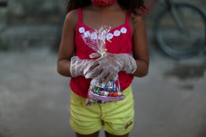 La alumna Layza Ribeiro da Silva sostiene una bolsa de dulces que recibió de su maestra, en Río de Janeiro, Brasil.