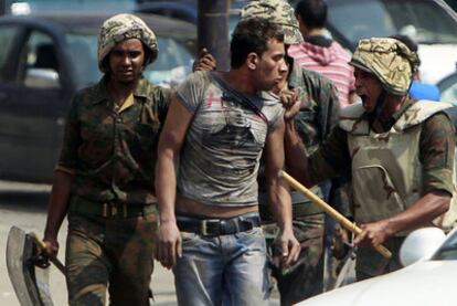 Dos soldados egipcios detienen a un hombre que intentaba acercarse a la Embajada israelí, ayer en El Cairo.
