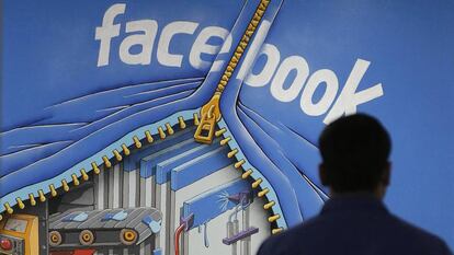 Un empleado pasa ante un cartel en la sede de Facebook en Menlo Park, Califonia.