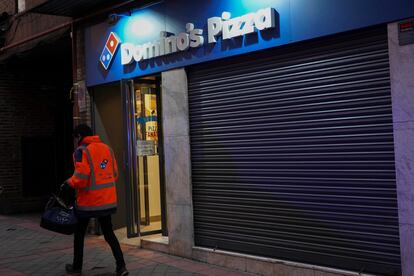 Un repartidor pasa frente al establecimiento de Domino's  Pizza de la calle Francos Rodríguez de Madrid.