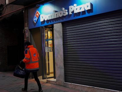 Un repartidor pasa frente al establecimiento de Domino's  Pizza de la calle Francos Rodríguez de Madrid.