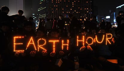 Estudiantes de Corea del Sur dibujan con letreros luminosos en Se&uacute;l la leyenda &quot;La hora del planeta&quot;.