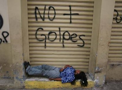 Una mujer duerme en un portal de Tegucigalpa.