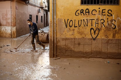 Un voluntario retira fango de una calle de Paiporta (Valencia), el 7 de noviembre.