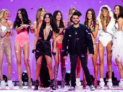 Selena Gómez y The Weeknd, ambos de negro en el centro, durante el desfile de Victoria´s Secret de 2015.