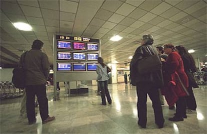 Pasajeros del aeropuerto de Barajas, el pasado sábado, ante un monitor que indicaba las cancelaciones de vuelos.