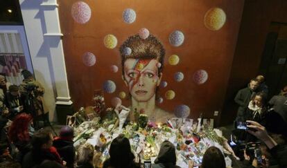 Homenajes por la muerte de David Bowie frente a un mural del cantante dibujado por el artista Jimmy C, en Brixtol, Londres.