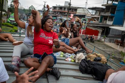 Mujeres celebran sobre una chiva porque están regresando a San Isidro, en vereda del Bajo Calima, el 14 de junio de 2024. 