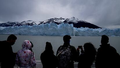 Turistas observan el Perito Moreno desde un barco.