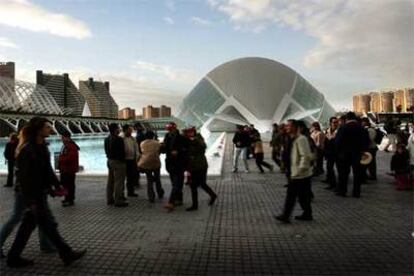 Visitantes pasean por la Ciudad de las Ciencias, con L&#39;Hemisfèric al fondo.