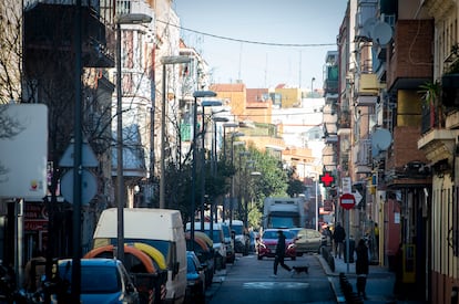 Un joven cruza la calle con un perro en la Avenida Monte Igueldo, en el distrito de Puente de Vallecas.