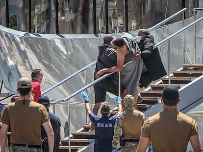 Rescatistas portan a uno de los supervivientes del naufragio de una embarcación cargada de personas que se hundió el 14 de junio frente a las costas griegas.