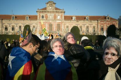 Manifestantes independentistas con caretas de Puigdemont han marchado en apoyo a la investidura del candidato.