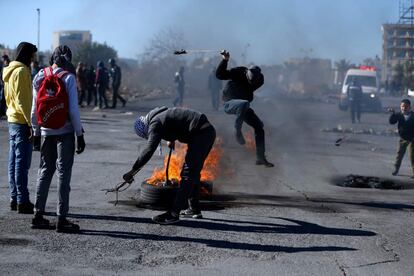 Manifestantes palestinos prenden fuego a un neumático durante un enfrentamiento contra las fuerzas de seguridad israelíes en Ramala, Cisjordania. 
