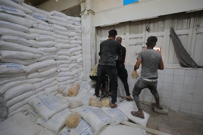 Un grupo de palestinos distribuyen bolsas de pan de una panadería del Programa Mundial de Alimentos (PMA) en el campo de refugiados gazatí de Nuseirat, este jueves.